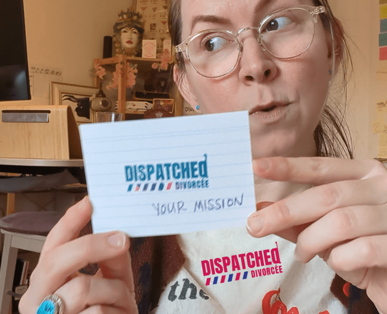 woman holding white card that says dispatched divorcee